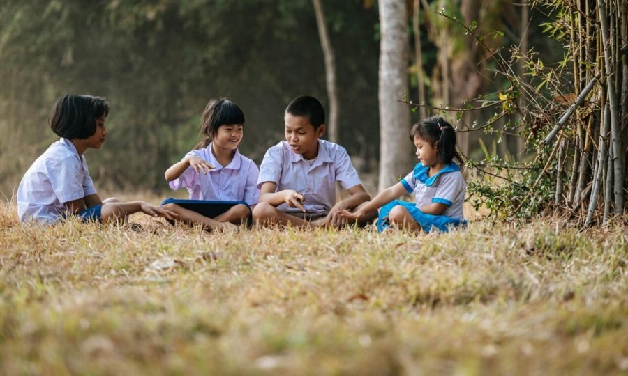 asian-boy-three-little-girls-student-uniform-sitting-grass-enjoy-play-hand-game-together-they-talk-laugh-with-funny-copy-space-rural-lifestyle-concept_1150-55897